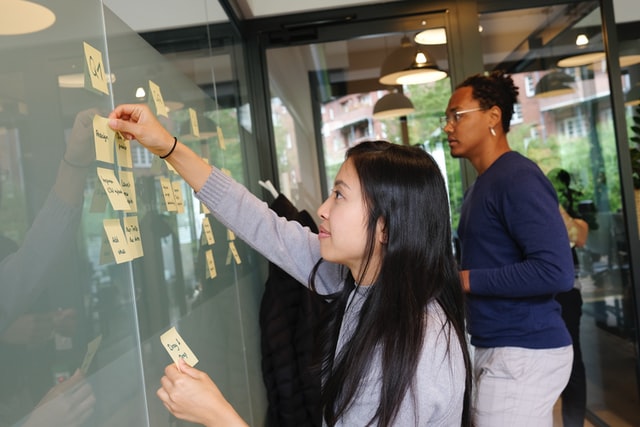 People with post-it notes on glass  screen
