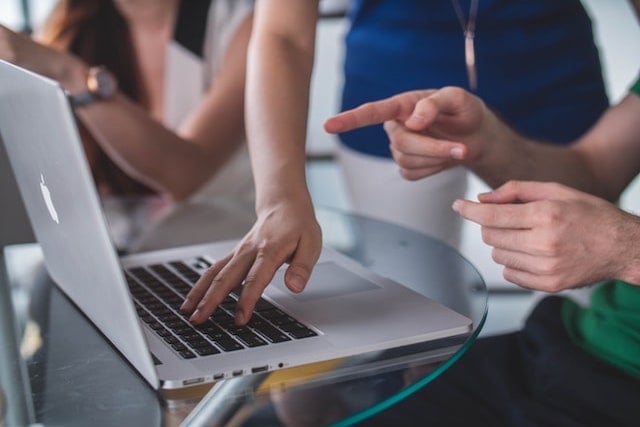 Trainer helping student with laptop obscured faces - small copy