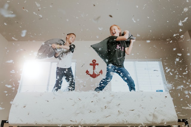 Two boys having a pillow fight